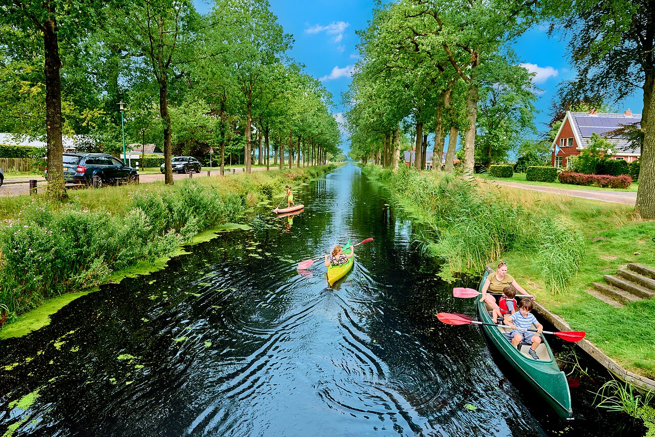 Famille en cano� et paddle sur le canal arbor� au camping CAPFUN De Waldsang � Bakkeveen.