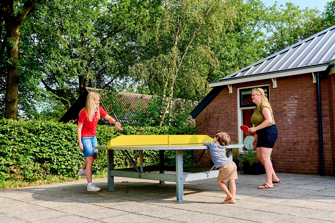 Famille jouant au tennis de table ext�rieur au camping CAPFUN De Waldsang � Bakkeveen.
