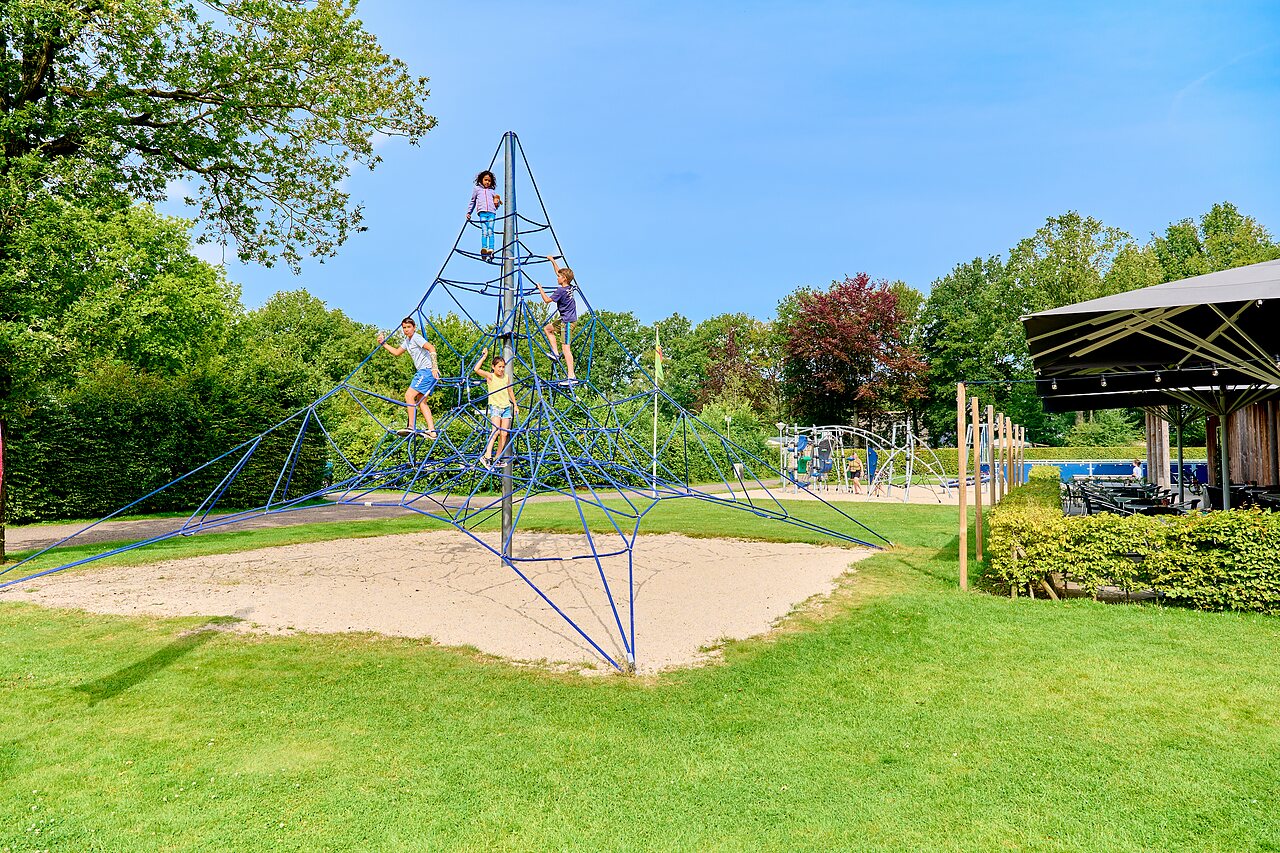 Enfants grimpant sur une structure de jeux en corde au camping CAPFUN De Waldsang � Bakkeveen.