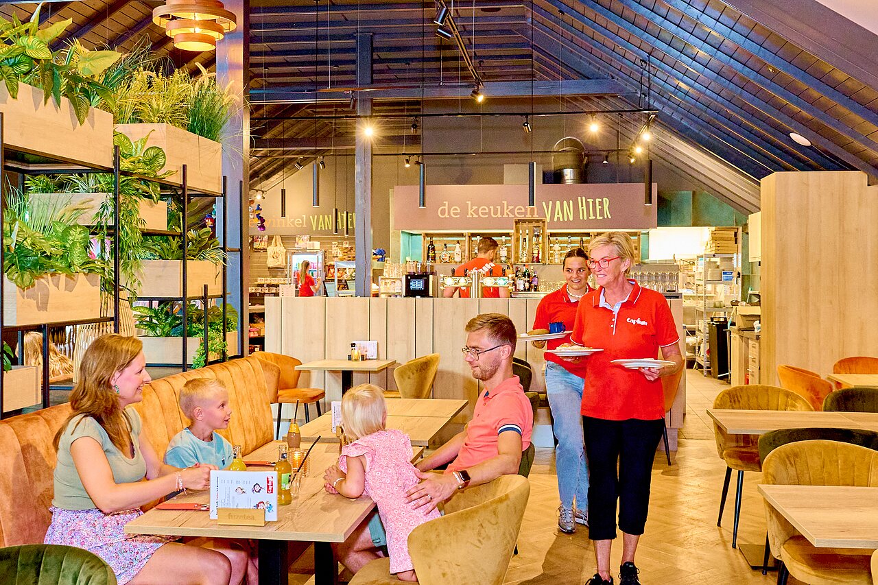 Famille d�nant au restaurant moderne avec bar au camping CAPFUN Wieskamp � Winterswijk Henxel.
