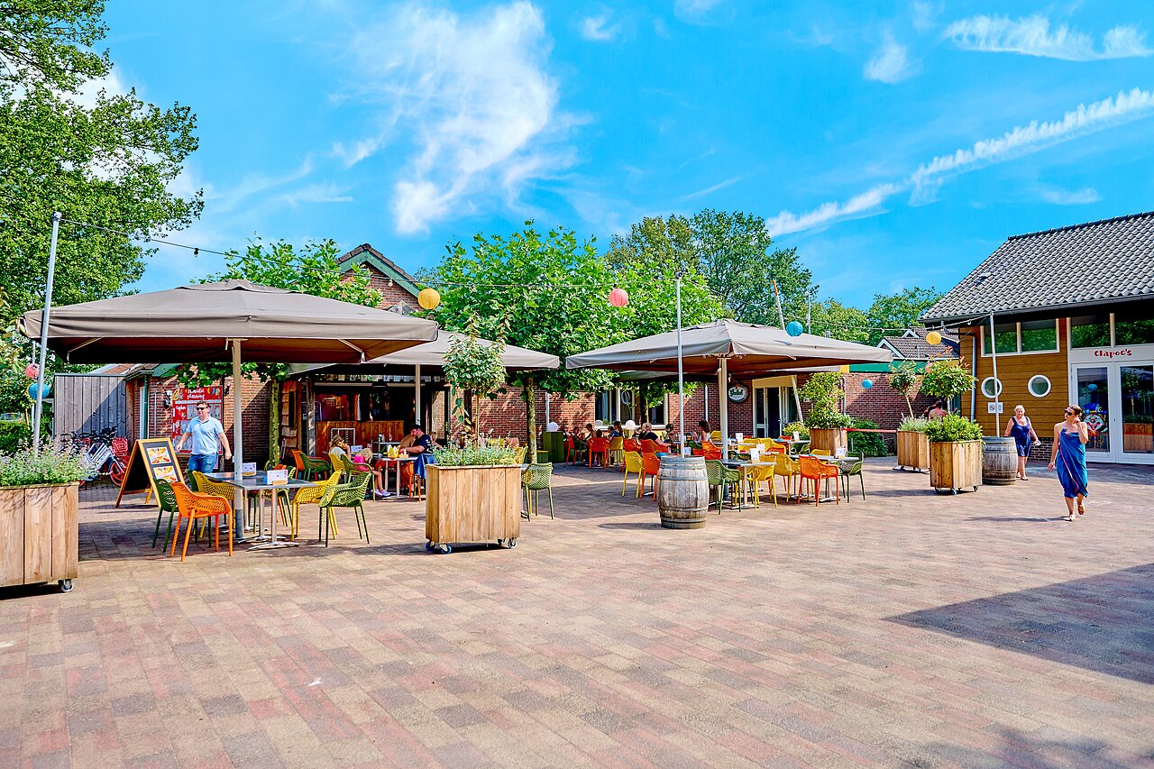 Terrasse de restaurant ext�rieure anim�e avec clients au camping CAPFUN Wieskamp � Winterswijk Henxel.
