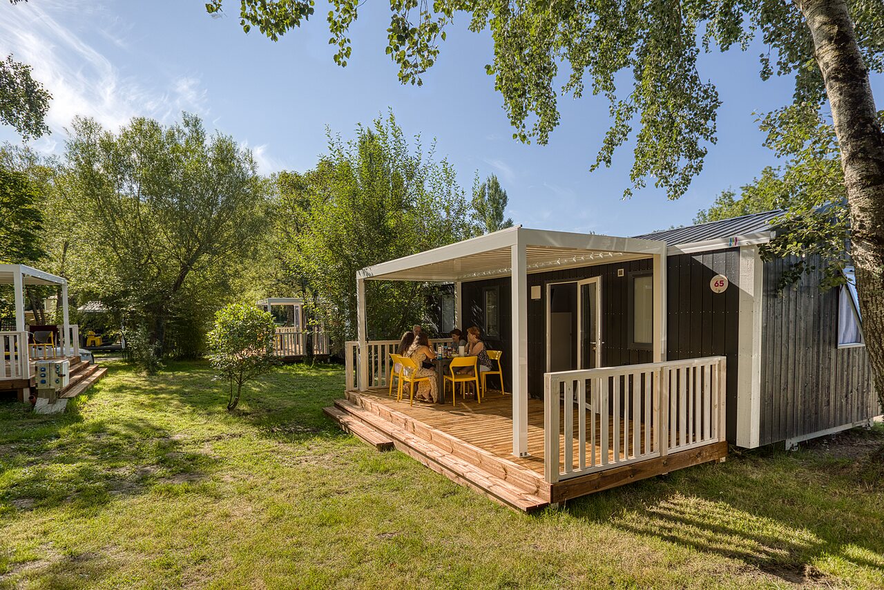 Modern Mobil-home met terras en gezin aan tafel op camping CAPFUN het Winkel in Winterswijk.