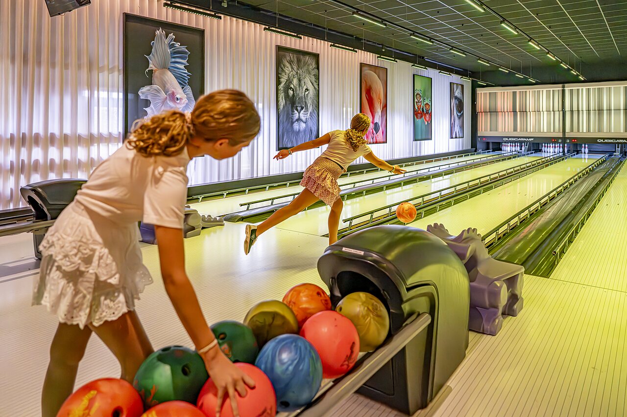 Twee jonge meisjes bowlen op een moderne baan op camping CAPFUN het Winkel in Winterswijk.