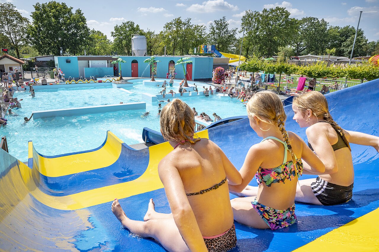 Enfants sur toboggan aquatique, piscine ext�rieure anim�e au camping CAPFUN de Wondermolen � Molenschot.