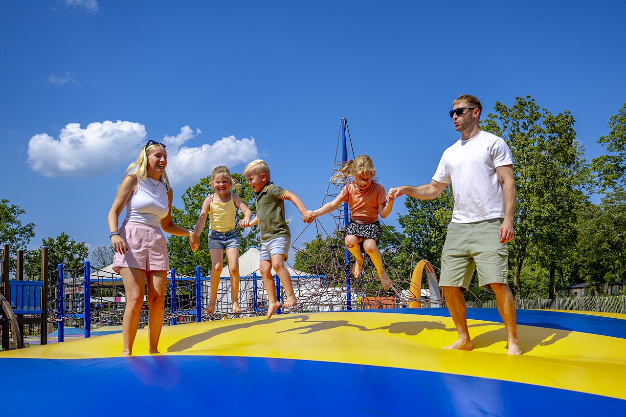 Famille sautant sur un coussin gonflable g�ant au camping CAPFUN de Wondermolen � Molenschot.