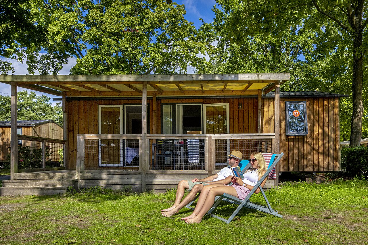 Couple se relaxant devant un mobile home au camping CAPFUN de Wondermolen � Molenschot.