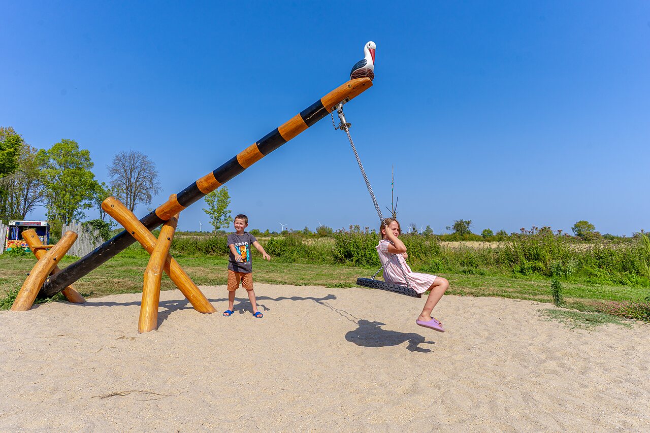 Enfants jouant sur une structure de jeu color�e, couple � v�lo au camping CAPFUN Zagarella � LONGEVILLE SUR MER (85).