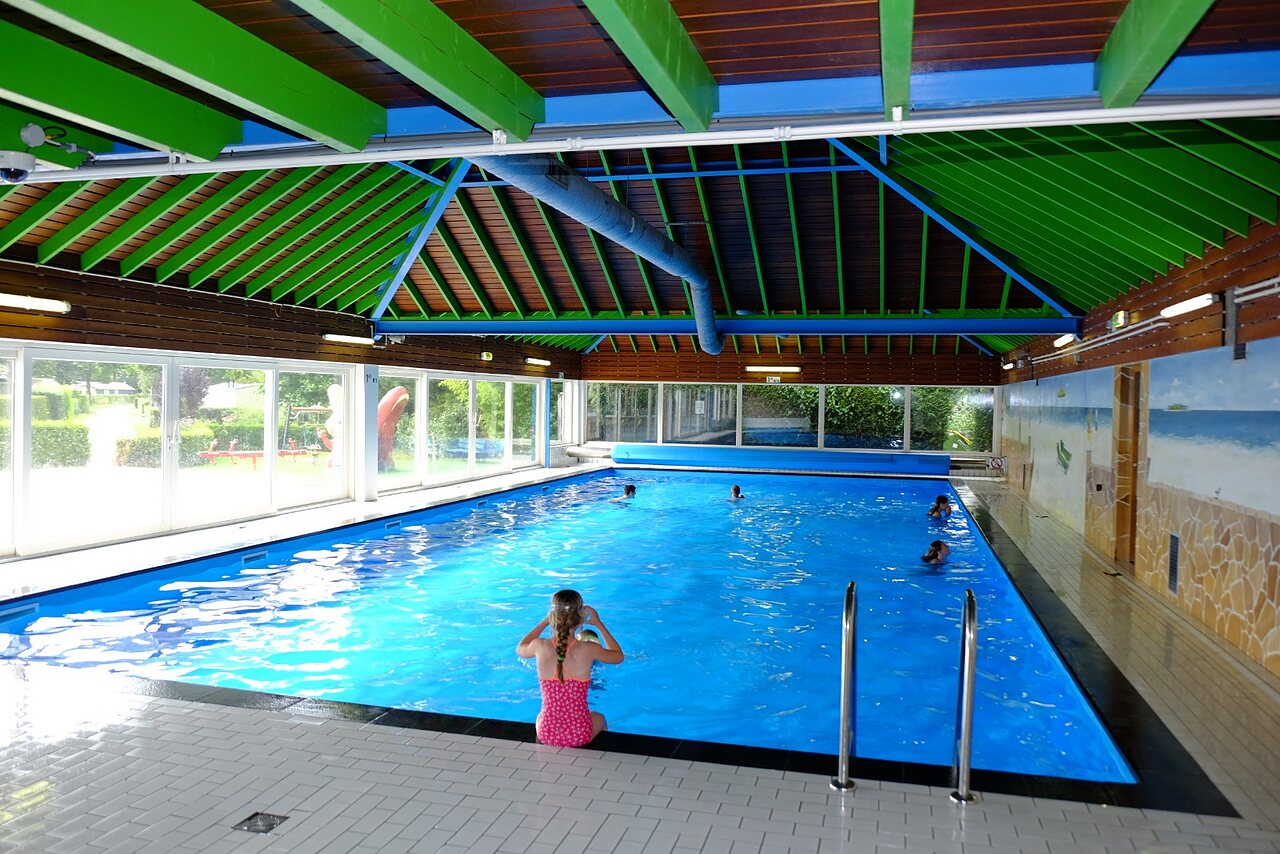 Piscine couverte avec enfants nageant et jouant au camping CAPFUN Zeumersehof � Voorthuizen.
