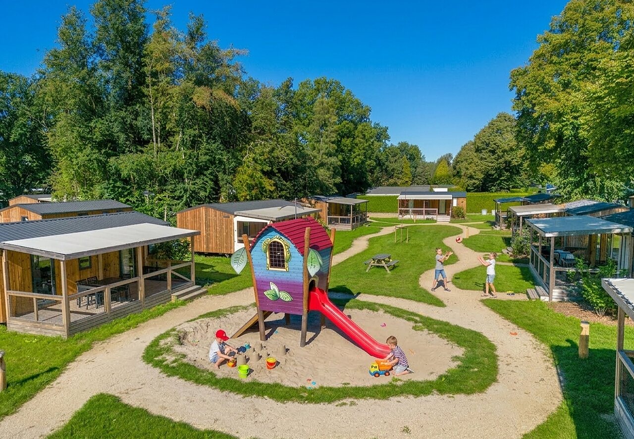 Aire de jeux avec toboggan et enfants, Mobil-homes au camping CAPFUN Zeumersehof � Voorthuizen.
