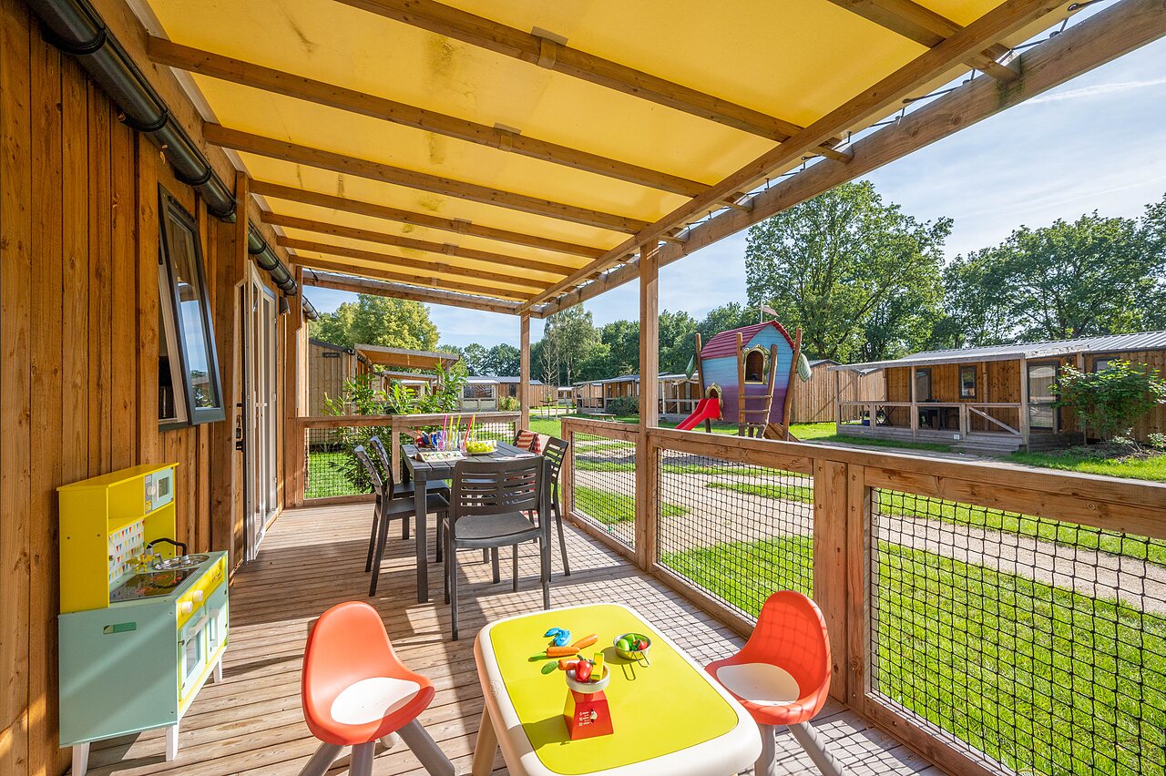 Terrasse de Mobil-home avec table � manger et jeux enfants au camping CAPFUN Zeumersehof � Voorthuizen.