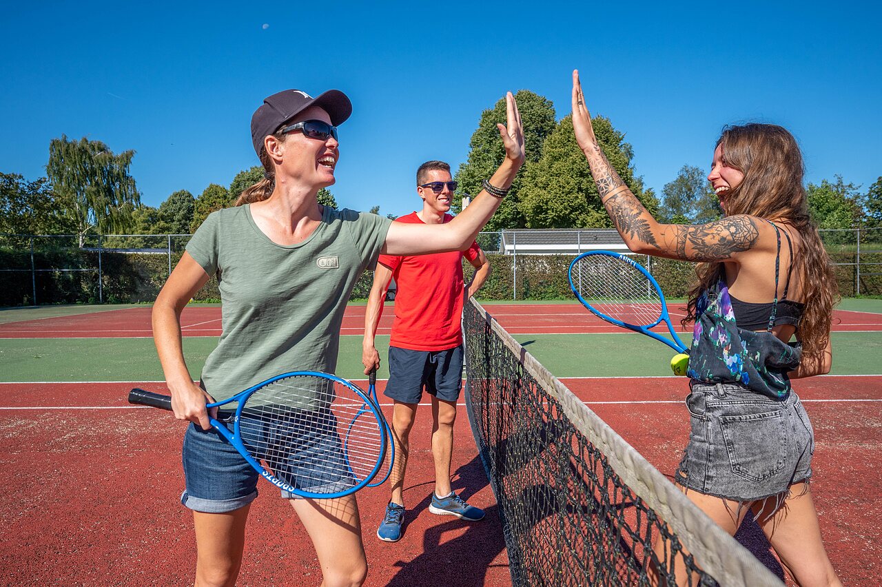 Joueurs de tennis souriants sur le court multisport au camping CAPFUN Zeumersehof � Voorthuizen.