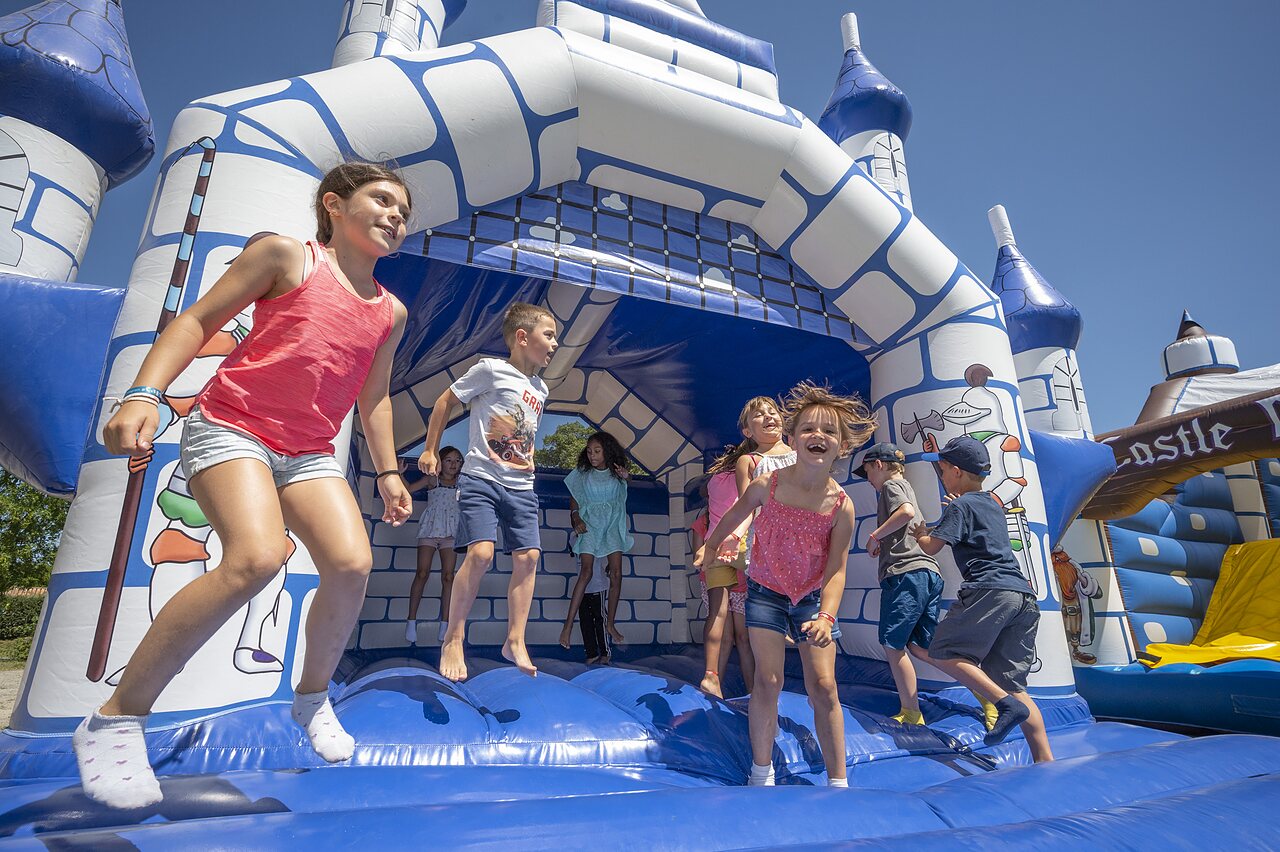 Enfants sautant sur un ch�teau gonflable bleu et blanc au camping CAPFUN Zeumersehof � Voorthuizen.